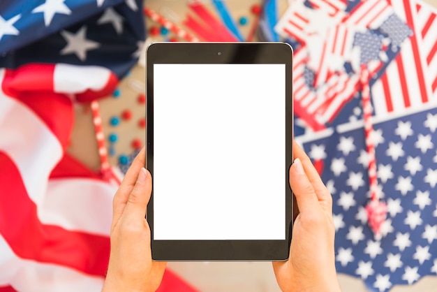 A close-up shot of a person's hands filling out an online voter registration form on a tablet. The background shows a patriotic theme with subtle American flag elements.