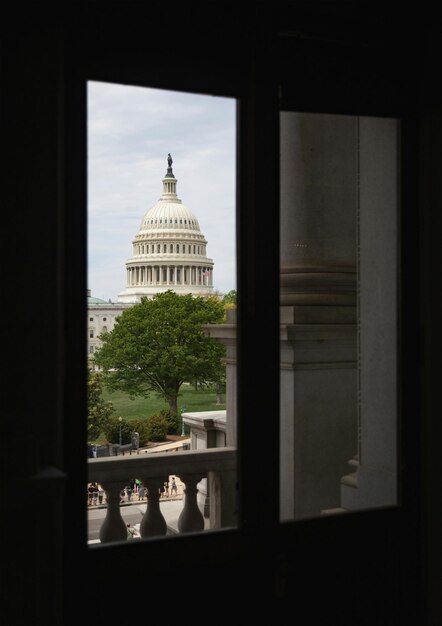 A split image showing the US Capitol Building with the House of Representatives chamber on one side and the Senate chamber on the other. Highlight the architectural grandeur and the symbolic representation of the two legislative bodies.
