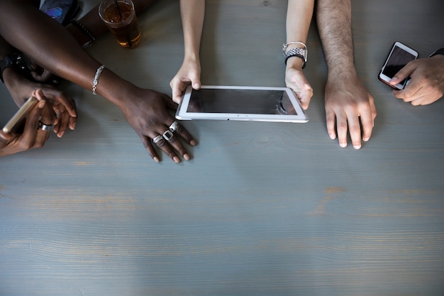 An image featuring hands of different ethnicities using various digital devices, all displaying election-related content, symbolizing the diverse demographics reached through social media.