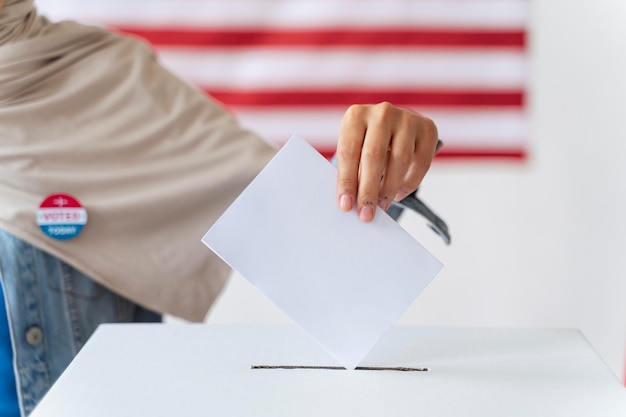 An image of a hand filling out a sample ranked-choice voting ballot, with close-ups of educational materials explaining how to rank candidates. Background elements include diverse hands and faces, symbolizing inclusivity in the voting process.