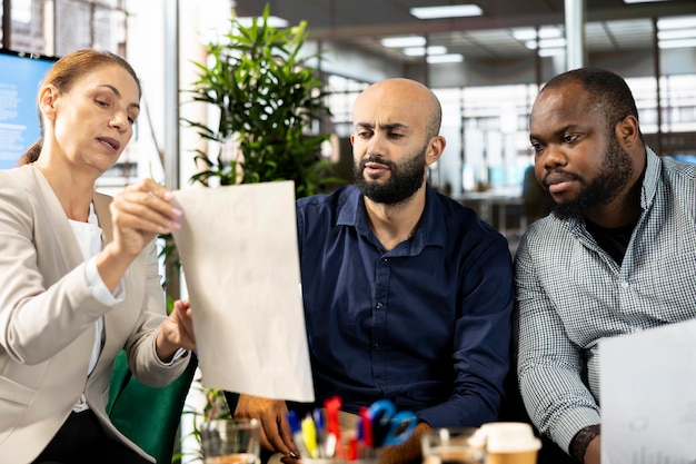 A diverse group of employees in a modern office, collaborating around a table, symbolizing teamwork and strategic planning in preparation for the upcoming changes to federal overtime rules.