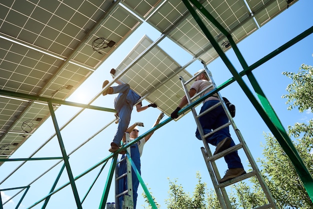 Solar panel technicians installing panels on a rooftop, emphasizing the creation of green jobs in the solar energy sector.