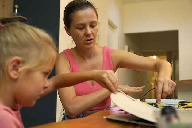 Close-up shot of a teacher helping a student with a learning disability, with adaptive educational materials visible in the background.