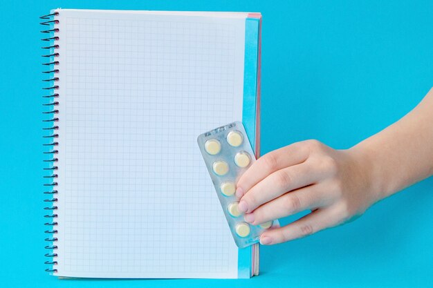 A close-up shot of a hand holding prescription pills, with a calculator and a Medicare Part D enrollment guide in the background. The focus is on affordability and cost management.