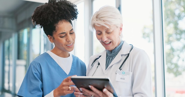 A friendly healthcare navigator assisting a person with their Medicaid application, using a tablet. They are sitting at a desk in a community health center, with informational brochures visible in the background.