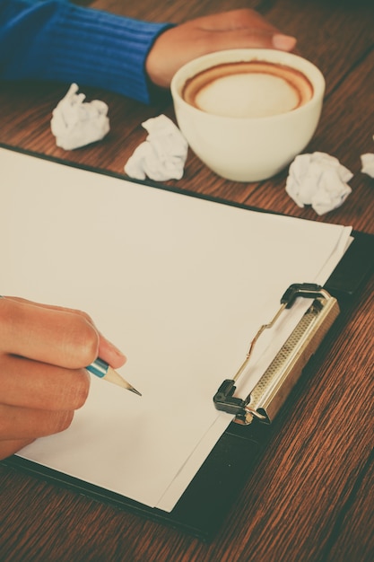 A person writing a detailed and organized appeal letter, with supporting documents neatly arranged beside them, conveying a sense of preparation and attention to detail.