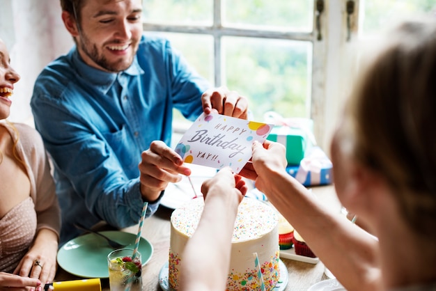 A family celebrating the birth of a new baby, with a health insurance card visible on the table, symbolizing the need for updated health coverage after a significant life event.