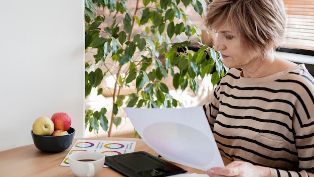A person using a calculator and reviewing a document with charts illustrating different health insurance costs (premiums, deductibles, copays). The scene emphasizes the importance of comparing costs.