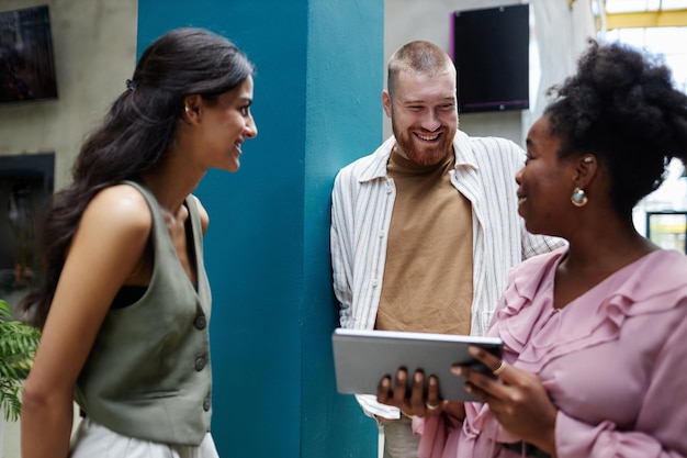 A diverse group of people looking at a tablet with a health insurance marketplace website displayed on the screen. They appear to be comparing different health plans and discussing the options.