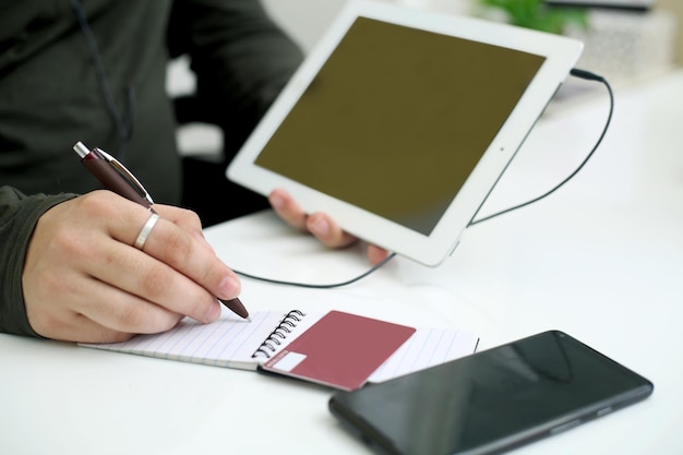 A close-up of hands filling out an online application form on a tablet, with icons representing internet connectivity and financial assistance visible in the background, symbolizing the ACP application process.