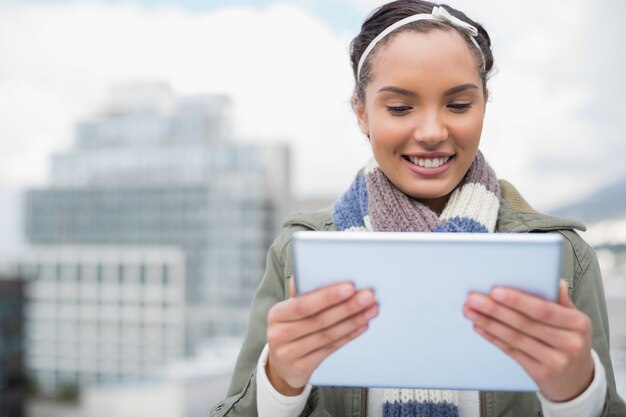 A person filling out an online application form for unemployment benefits on a tablet, with a government building in the background.