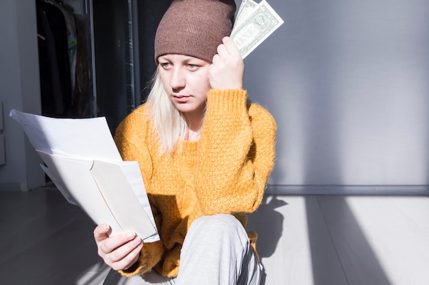 A person looking at a stack of bills with a worried expression, symbolizing the financial strain on low-income beneficiaries.
