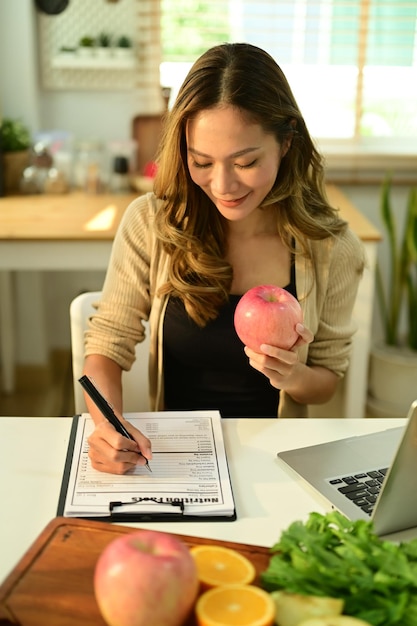 A person using a calculator and a budget planner with grocery receipts organized next to them, focusing on managing finances and calculating SNAP benefits.