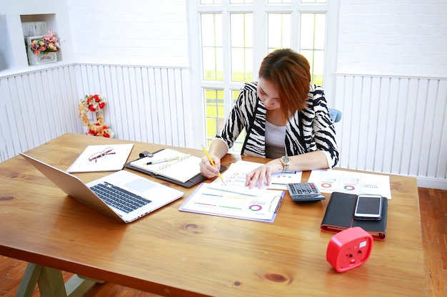 A person sitting at a desk reviewing documents related to student loans, with a calculator and pen nearby, highlighting the process of understanding loan details and forgiveness options.