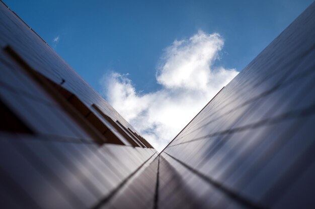A close-up view of solar panels installed on a residential rooftop, with sunlight reflecting off the panels. The image showcases the detailed structure of the solar panel array and its integration with the roof.