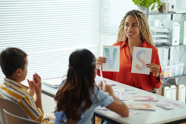 A single mother attending a job training workshop with a facilitator explaining the key points of resume or cover letter writing, in an informal and inclusive setup. The room is bright and conducive to learning.
