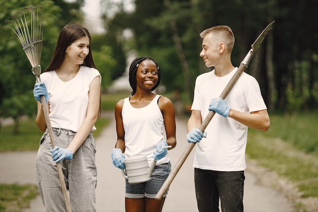 A diverse group of people in a community service event, cleaning up a local park. They are wearing gloves and picking up trash, demonstrating an active engagement in improving their community.