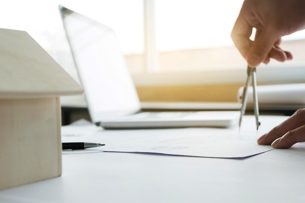 A close-up of a hand filling out a housing assistance application form on a table with a pen and other documents. The image emphasizes the application process.